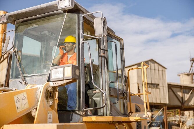 Man in hardhat and safety vest operating heavy equipment