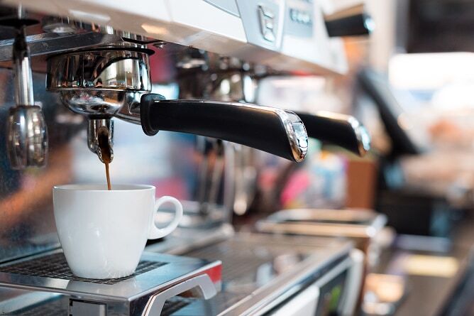 Closeup of espresso being pulled from machine into small cup