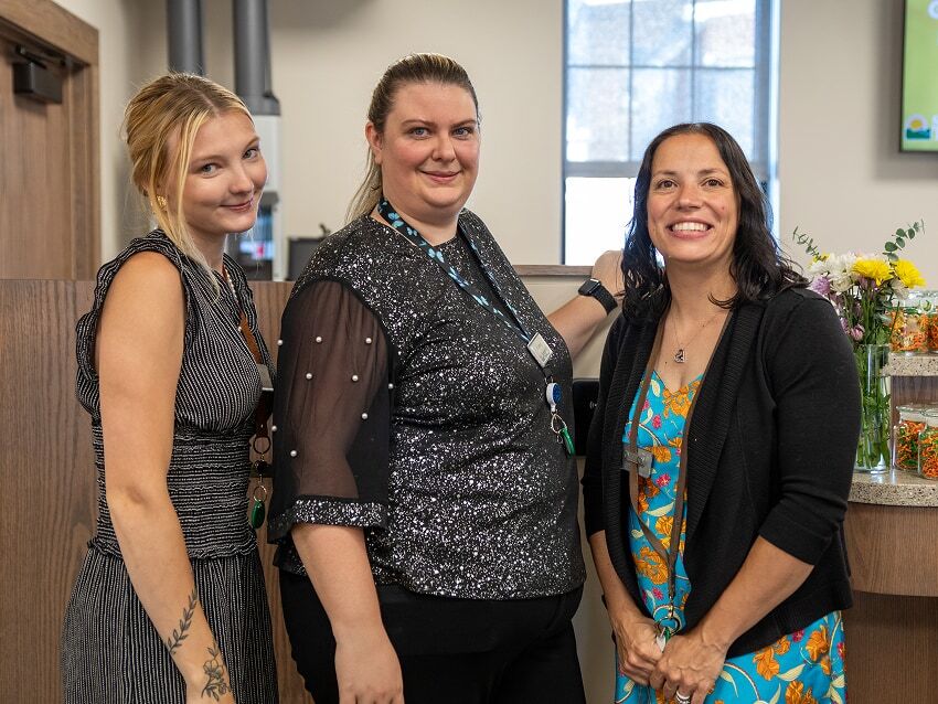 Three tellers standing in branch lobby