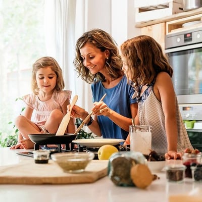 Mother and two daughters cooking in kitchen