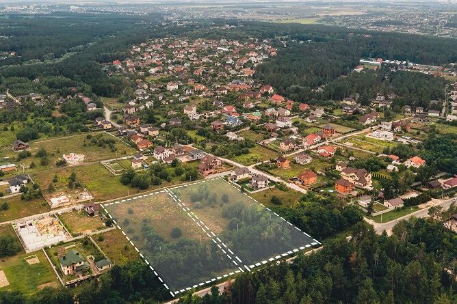 Aerial shot of land with available plots highlighted
