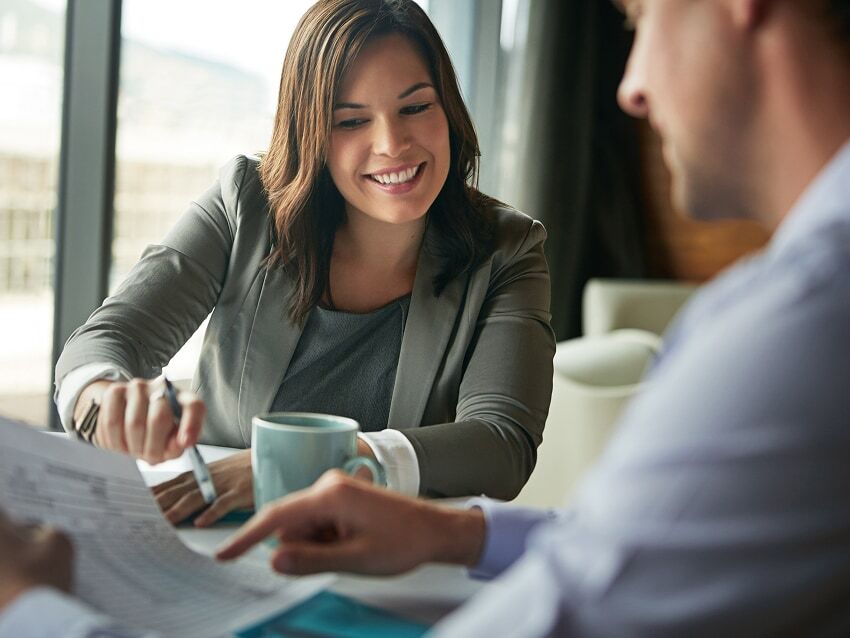  Business woman showing man financial report in an office