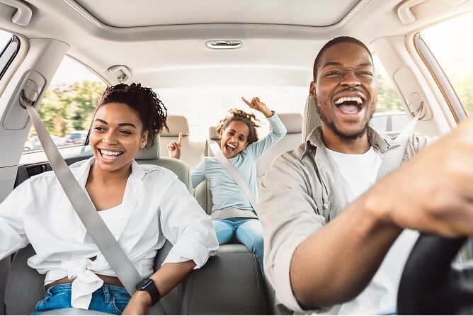 Family of 3 riding in car with windows down and singing
