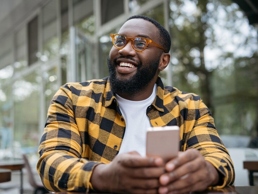 Man sitting outside of business on his phone