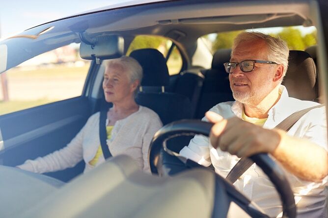 View through windshield of man driving car and woman in passenger seat