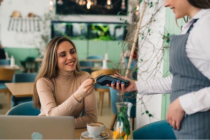 Young woman paying with credit card at a restaurant