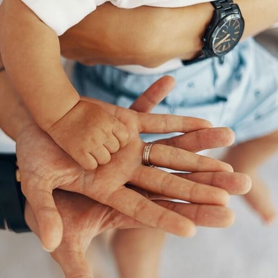 Father’s, mother’s, and baby’s hand stacked on top of each other